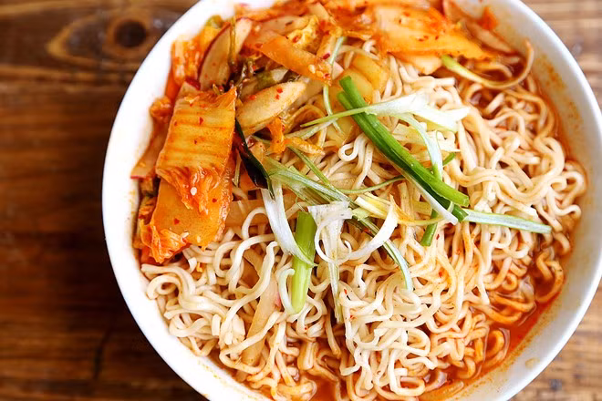 Mì kim chi: Nước dùng từ kim chi đem lại cho bát mì nóng vị chua cay dễ ăn. Kim chi, nước kim chi, giá, rượu trắng, bột ớt, xì dầu được xào chín, thêm nước, nêm gia vị. Sau đó, cho mì vào nấu cho tới khi chín mềm, dọn ra bát và trang trí bằng hành tươi. Ảnh: Divine Healthy Food.