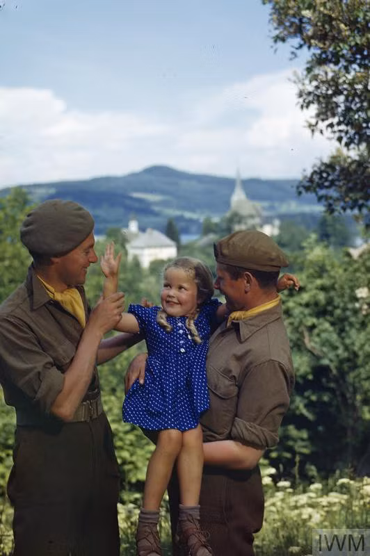 Hai người lính vui đùa bên một bé gái 4 tuổi ở Klagenfurt, Áo tháng 5/1945.