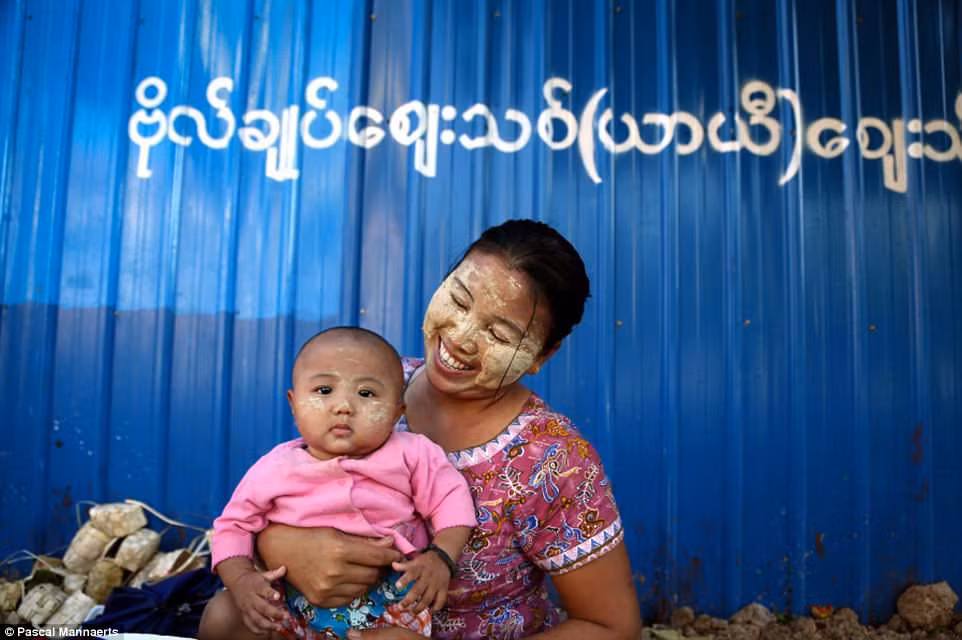 Người mẹ rạng rỡ hạnh phúc ôm người con bé nhỏ trong lòng. Ảnh chụp ở ở Rangoon, Myanmar năm 2014.