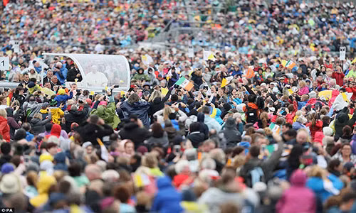 Đám đông vẫy cờ Ireland và Vatican khi chiếc xe chở Đức Giáo hoàng đi qua.