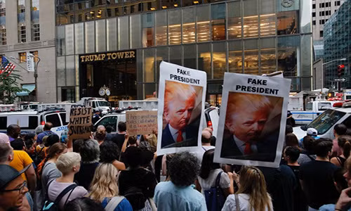 Biểu ngữ "Tổng thống giả", nhái theo lời cáo buộc "tin giả" ông Trump gắn cho CNN. Bạo loạn nổ ra tại Charlottesville thuộc bang Virginia hôm 12/8 sau khi các nhóm ủng hộ da trắng và phát xít mới đụng độ với các nhóm chống phân biệt chủng tộc. Cuộc bạo loạn đã khiến 1 người thiệt mạng và 19 người bị thương. Đây được coi là hồi chuông cảnh báo về sự chia rẽ sắc tộc vốn vẫn âm ỉ trong lòng xã hội Mỹ.