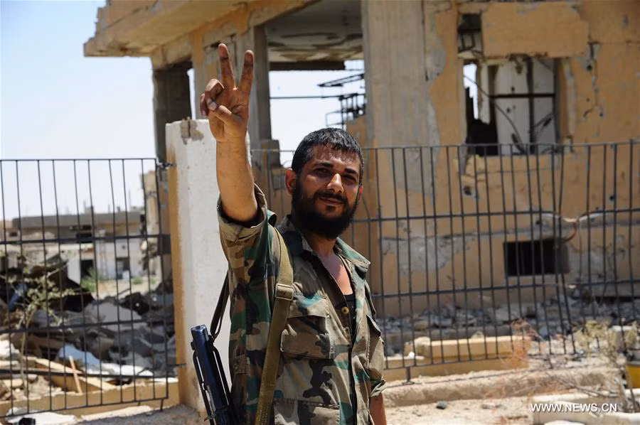 Một binh sĩ Syria giơ tay biểu tượng chiến thắng ở thị trấn al-Sukhnah ngày 13/8. Ảnh: THX.