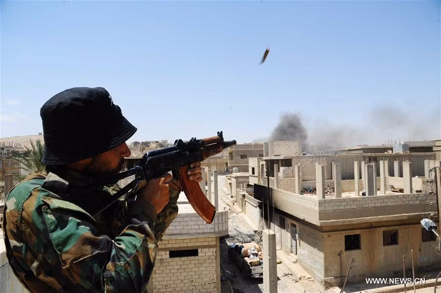 Một binh sĩ Syria bắn loạt đạn mừng chiến thắng tại al-Sukhnah ngày 13/8. Ảnh: THX.