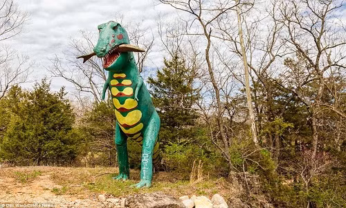 Bức tượng một con khủng long bạo chúa T-Rex khổng lồ đang ngậm con mồi của nó. Các công trình hiện bị bỏ hoang trong công viên khủng long Dinosaur World ở Arkansas, Mỹ.