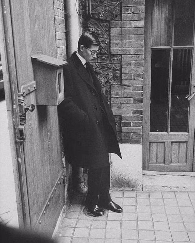 Khoảnh khắc Yves Saint Laurent suy tư tại đám tang của Christian Dior, Paris vào năm 1957. Đây là sự kiện đánh dấu bước ngoặt to lớn khi Saint Laurent trở thành giám đốc nghệ thuật – người đứng đầu đầy quyền lực của thương hiệu Dior.