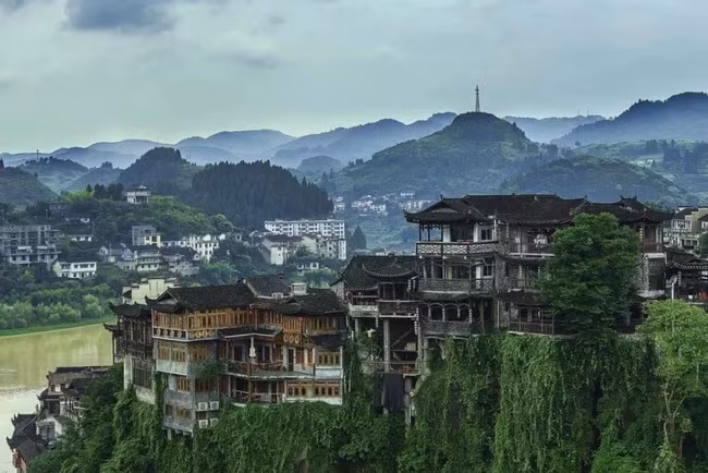 Đây là kiểu nhà sàn được xây dựa theo độ dốc của thế núi, nửa sau nhà nằm trên bề mặt núi, còn nửa trước chìa ra ngoài, trụ là những cột chống gọi là Điểu Cước. Xây nhà trên vách đá giúp tiết kiệm đất, đồng thời cũng mang tính an toàn quân sự cao và thuận tiện cho giao thông thủy.