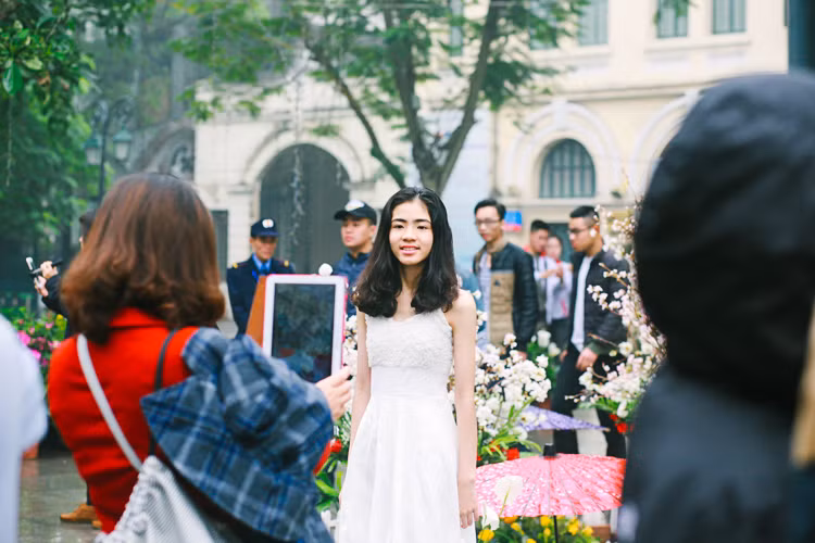 Họ thường nhờ người khác chụp ảnh cho mình hoặc cùng nhau selfie rất vui vẻ, tận hưởng không khí tuyệt vời ở lễ hội hoa anh đào bất chấp trời mưa, ẩm ướt.