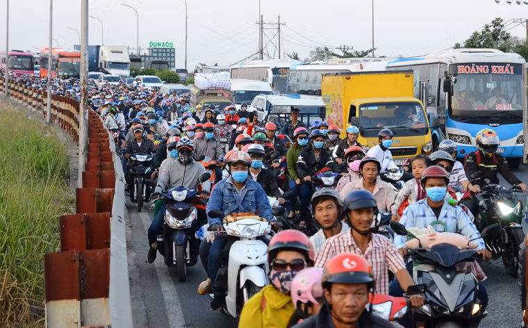 Nhiều gia đình với đồ đạc, quà tết lỉnh kỉnh rời thành phố bằng xe máy về quê ăn Tết.