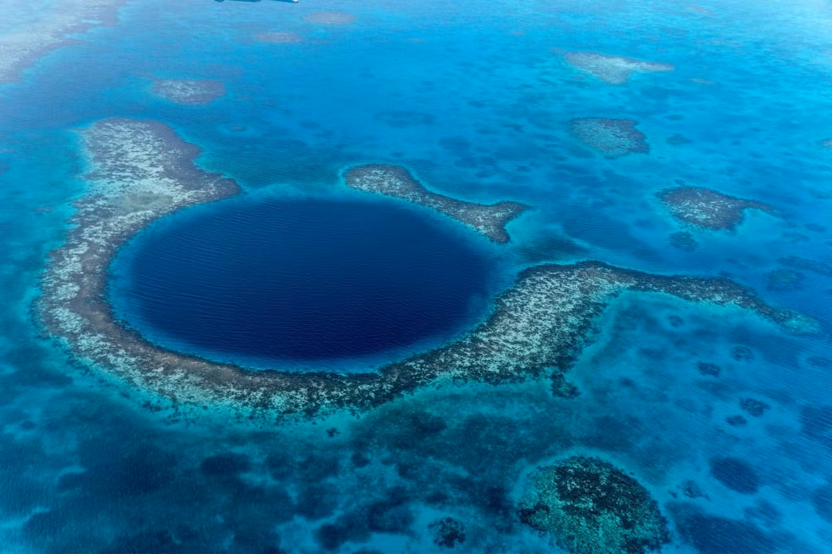 Hố xanh khổng lồ (Great Blue Hole). Vực sâu này có hình tròn, đường kính chừng 300 mét và sâu hơn 100 mét. Vực sâu này vốn hình thành từ một hệ thống hang động đá vôi trong suốt kỷ băng hà. Khi nước biển dâng cao, trần động sụp xuống tạo thành vực sâu như hiện nay. Ảnh The Unknown Blue