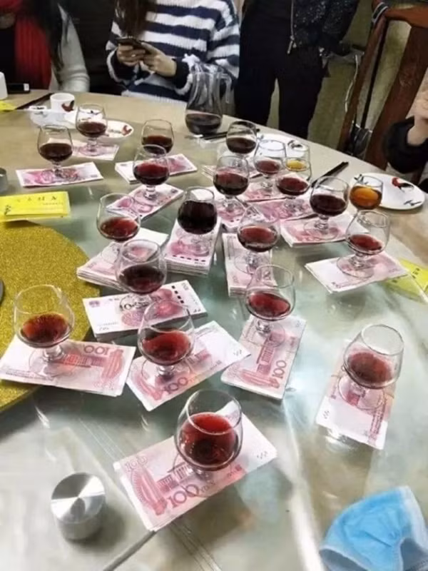 Cảnh tượng này chẳng khác nào đang rót rượu tại lễ cưới. Người ‘lời' nhất trong cuộc phát lì xì này có lẽ là người đầu tiên, khi chỉ phải uống một cốc.