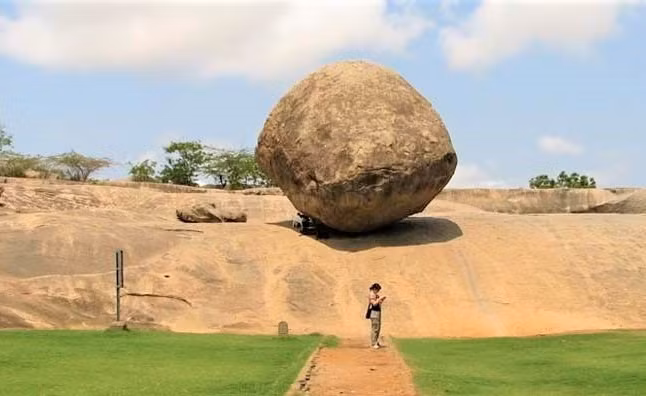 Tảng đá Krishna’s Butterball ở Ấn Độ là một trong những tảng đá giữ thăng bằng nổi tiếng nhất thế giới. Cao 6m và nặng khoảng 250 tấn, tảng đá khổng lồ đứng trên một chân đế cao 4m trên một ngọn đồi trơn trượt. Trải qua hàng ngàn năm, Krishna’s Butterball dường như thách thức mọi trọng lực khi không bị rơi xuống dưới. Ảnh: factsc.com.