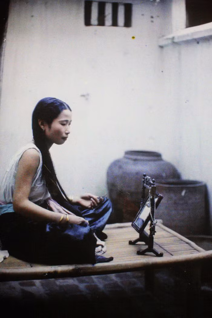 Một cô gái Hà Nội ngồi trước gương. Ảnh: Léon Busy.
