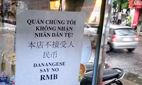 Nhạc sĩ Nguyễn Duy Khoái treo bảng thông báo không nhận Nhân dân tệ ngay trước quán nước của mình. Ảnh: H. Long.