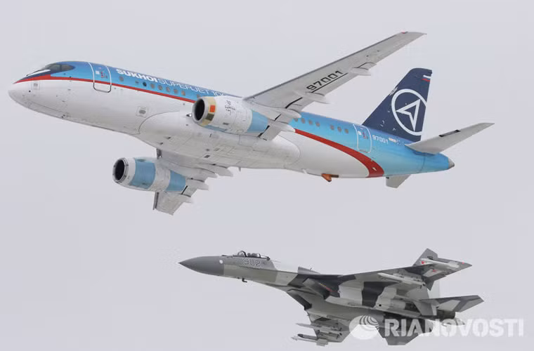 Trong ảnh là một chiếc Su-35 bay biểu diễn cùng mẫu máy bay chở khách thương mại Sukhoi Superjet 100 tại một triển lãm hàng không.