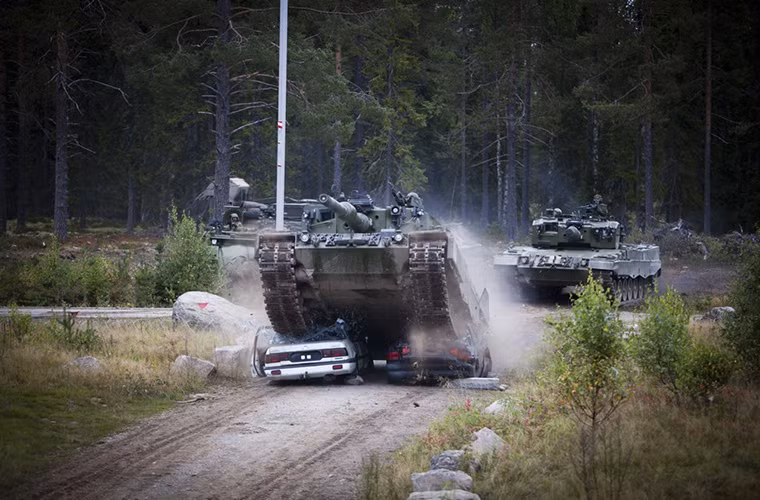 Cận cảnh một chiếc Leopard 2A4 cán nát hai chiến xe hơi cùng một lúc trên đường đi của nó, đây là cách huấn luyện vượt vật cản hiệu quả đối với các đơn vị xe tăng ở một số quốc gia.
