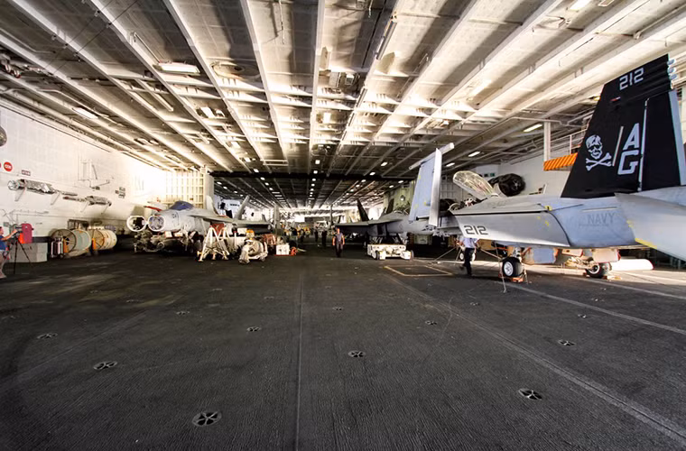 Khoang chứa máy bay bên dưới boong tàu USS Eisenhower, được biết mỗi tàu sân bay nguyên tử lớp Nimitz có thể mang theo tới 90 máy bay các loại trong mỗi đợt hành trình dài ngày trên biển.