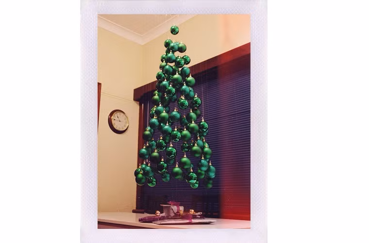 1. Thông Noel treo: Bằng cách sử dụng những vật liệu như bóng tenis, bóng bàn, những quả cầu trang trí Noel hoặc bất cứ vật dụng gì bạn có, hãy kết chúng lại và treo lên theo hình tháp, nối thêm đèn nhấp nháy, kim tuyến (nếu có điều kiện). Vậy là bạn đã có một cây thông Noel lơ lửng trong nhà.