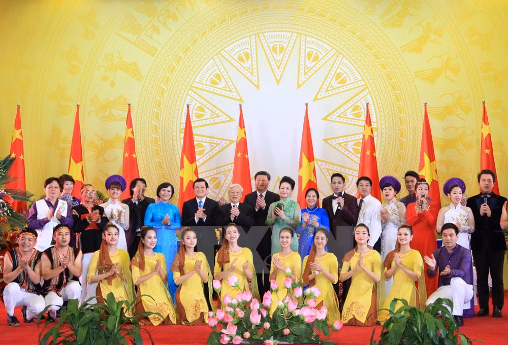 Tổng Bí thư Nguyễn Phú Trọng và Phu nhân; Chủ tịch nước Trương Tấn Sang và Phu nhân cùng Tổng Bí thư Tập Cận Bình và Phu nhân chụp ảnh chung với các nghệ sỹ tại buổi tiệc chiêu đãi. (Ảnh: Thống Nhất/TTXVN).