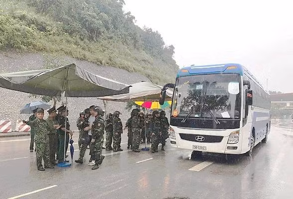 Các nghi phạm người Trung Quốc được đưa xuống xe, dẫn độ sang bàn giao cho phía Trung Quốc.
