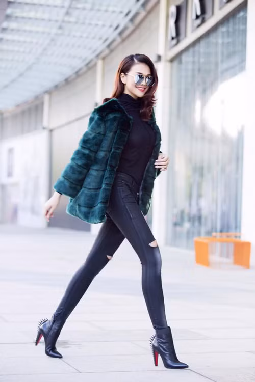 Thanh Hằng sang chảnh khi diện cả cây đen gồm, áo cổ lọ, quần jeans rách trẻ trung, kính mát, boot đinh tán Louboutin và chiếc áo khoác lông thời thượng mang lại sự quyền lực cho chân dài. Ảnh: eva.vn.