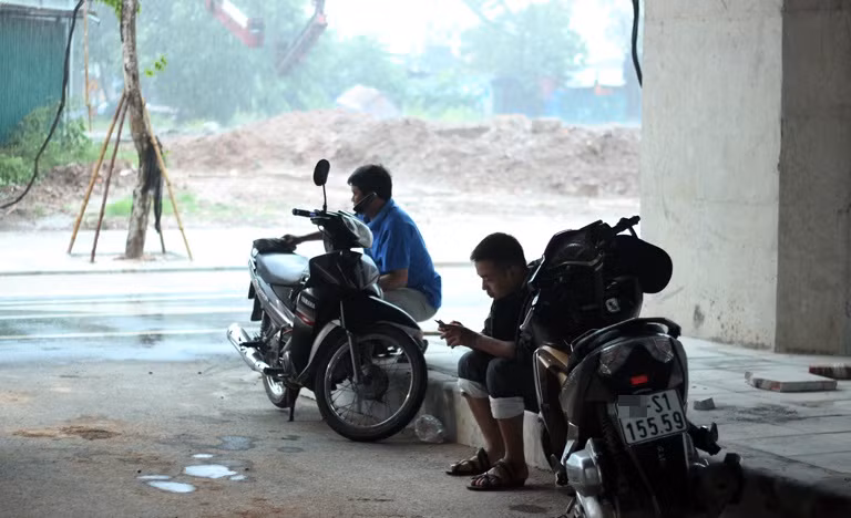 Nhiều người đi đường không kịp chuẩn bị áo mưa đành chui dưới gầm cầu để trú mưa.
