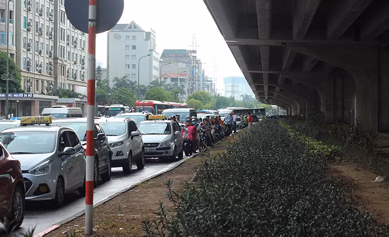 Nhiều ô tô, xe máy không thể di chuyển được đành phải chờ đợi nối đuôi nhau ùn ứ kéo dài trên đường Phạm Hùng.