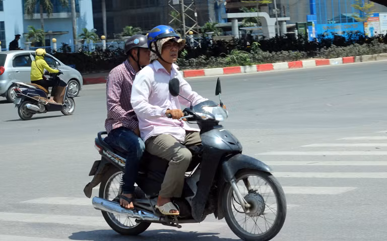Một số người khác thì đội hai lớp mũ trên đầu khi đi dưới nắng nóng ở Hà Nội.