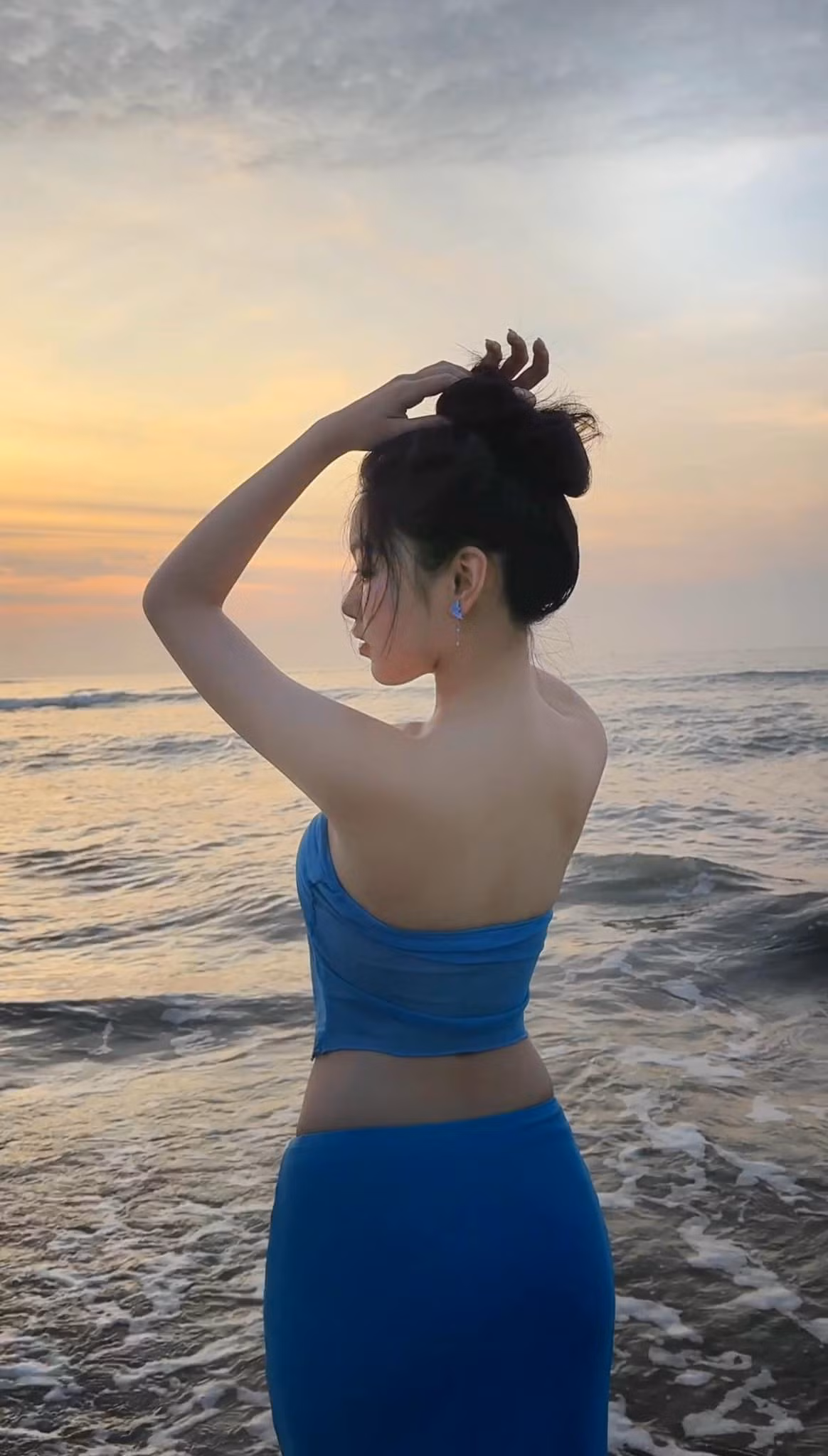 Mới đây, Lọ Lem đã chia sẻ lên TikTok cá nhân đoạn video nhảy múa trên bãi biển. Con gái đầu lòng của Quyền Linh diện chiếc váy xanh ôm sát cơ thể, phần áo có chi tiết cắt xẻ táo bạo giúp khoe khéo vóc dáng xinh đẹp.
