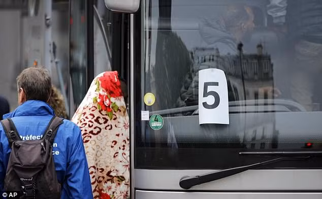 Những người dân nhập cư lên xe buýt ở Paris. Ảnh: AP.