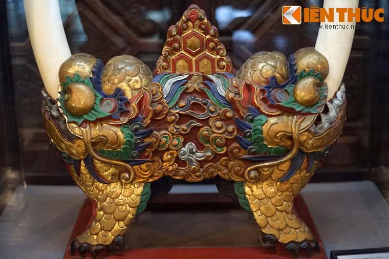 Phần giá gỗ được tạo hình lân rất sinh động với phần miệng ngậm lấy ngà. Bốn chân của con lân cũng là chân của giá gỗ.