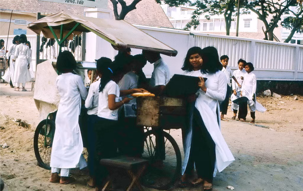 Các nữ sinh tụ tập bên quầy bánh mì bên ngoài một ngôi trường ở Vũng Tàu. Ảnh: Terry Maher.