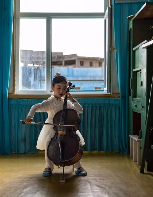 Ảnh chụp một bé gái chơi cello tại trường mẫu giáo Chongam ở Chongjin.