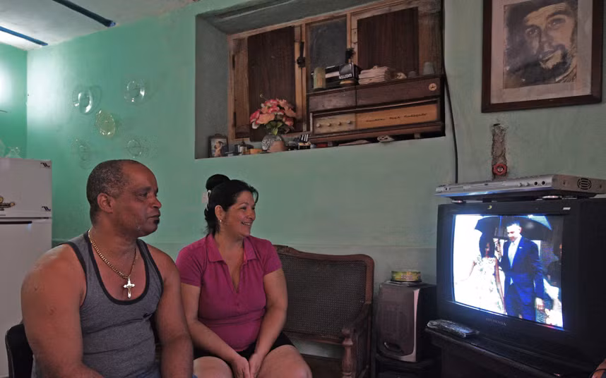 Hai vợ chồng sinh sống ở La Habana theo dõi ti vi đang chiếu bản tin nói về chuyến thăm lịch sử Cuba của Tổng thống Obama.