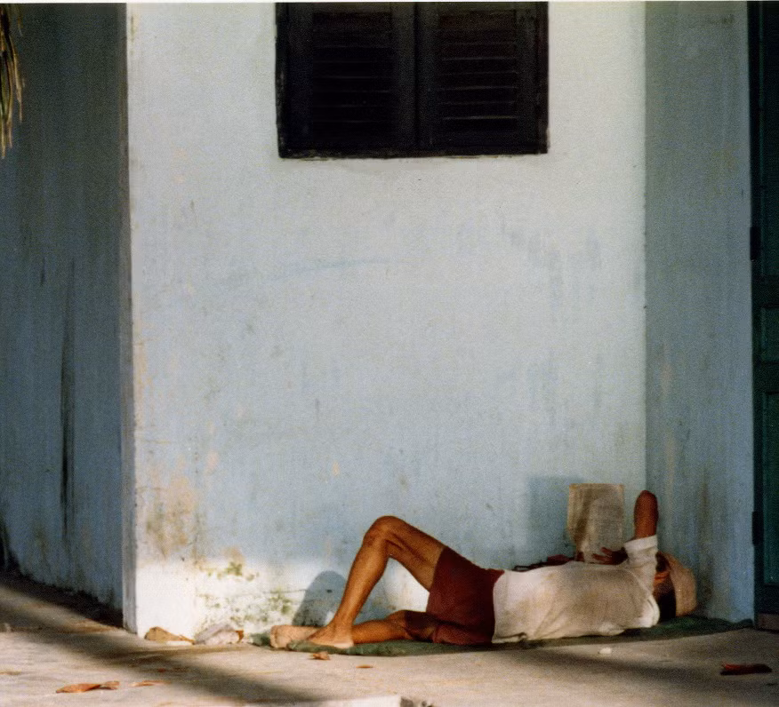 Một người nằm đọc báo.
