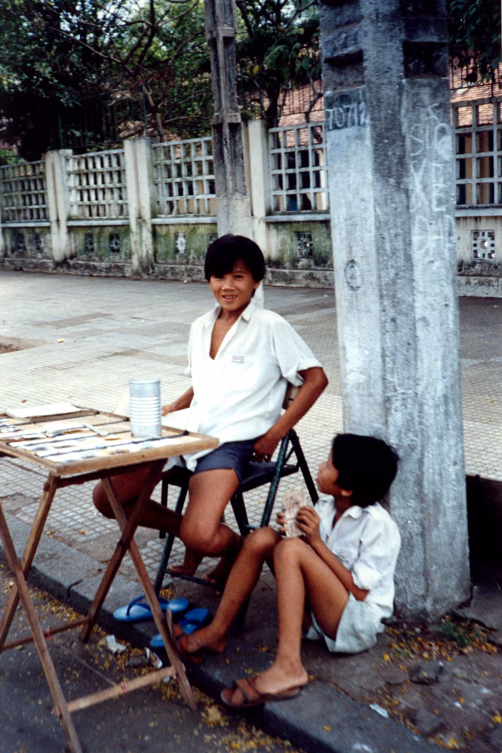 Hai cậu bé ở quầy vé số vỉa hè.