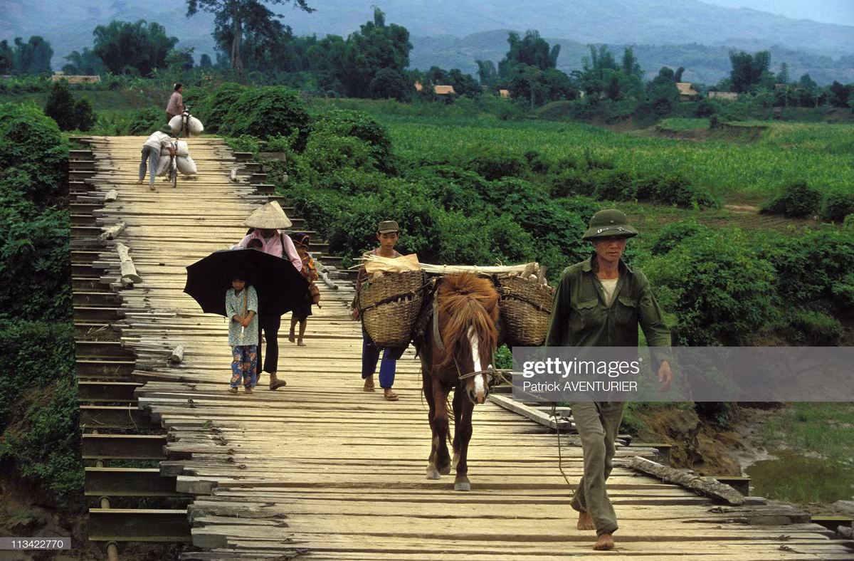 Người dân di chuyển trên cây cầu bắc qua sông Nậm Rốm.
