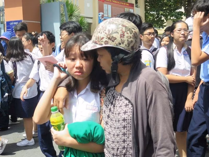 Một phụ huynh động viên con sau kỳ thi căng thẳng. Ảnh: Pháp luật TP HCM.