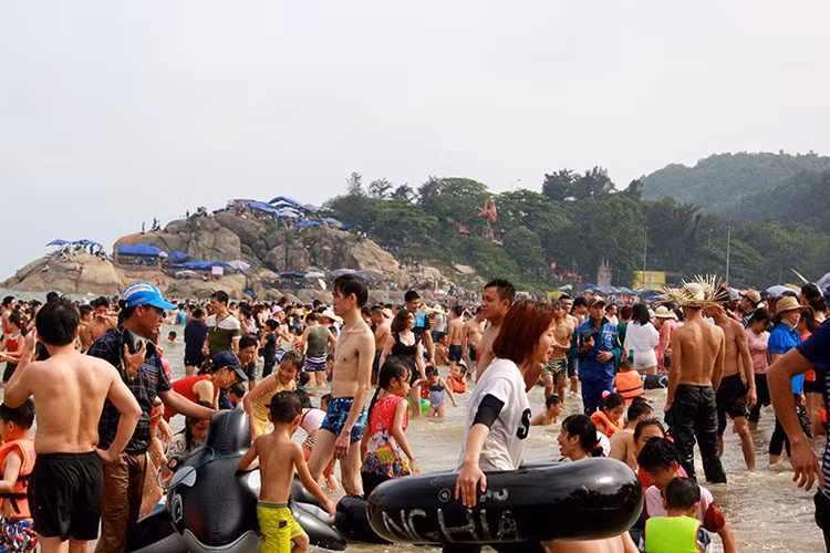 Do số lượng du khách Sầm Sơn đổ ra bờ biển khá đông nên một số người chỉ có thể đứng trên bờ vui chơi.