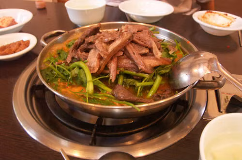 Cách làm món lẩu thịt chó cũng khá dễ và nhanh chóng. Bạn chỉ cần cho xương chó vào nồi ninh lấy nước lẩu, sau đó chặt thịt chó ướp kĩ trước khi nhúng lẩu. Ảnh: Dulichnamdinh.