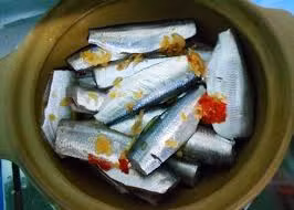 Trước khi chế biến, bạn cần chuẩn bị cá trích tươi, tỏi, ớt, nước dừa và các loại gia vị đi kèm. Cá sau khi làm sạch xếp vào nồi, cho nước dừa và các gia vị đã chuẩn bị chêm thêm mắm vừa miệng rồi kho tới khi cạn sạch nước. Ảnh: Toinayangi.