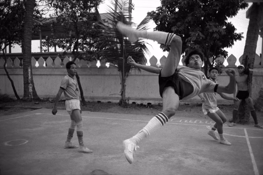 Trận đấu cầu mây tại sân một ngôi chùa ở Vientiane, 19/3/1994. Ảnh: John Vink / Magnum Photos.