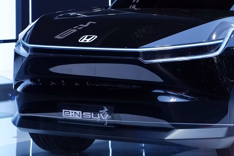 Ở khu vực đầu xe, Honda e:N SUV Prologue được trang bị lưới tản nhiệt đóng kín và dải đèn LED định vị ban ngày nằm vắt ngang, ôm lấy nắp ca-pô. Ngoài ra, dải đèn LED định vị ban ngày còn bao quanh cụm đèn pha có thiết kế khá mỏng. Bên trong cụm đèn pha này có 2 dải đèn hình chữ "L".