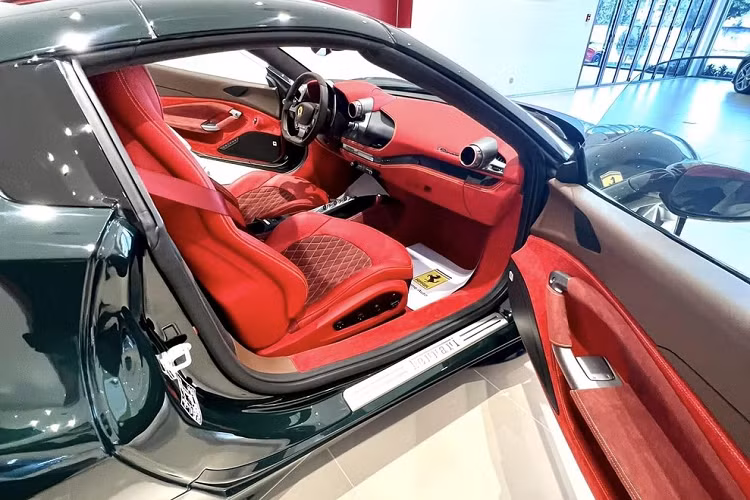 Điểm tương phản trong khoang lái của xe Ferrari F8 Spider này chính là vô lăng, 1 chút bằng điều khiển trung tâm hay phần bảng điều khiển ở cần số có màu đen. Vì là phiên bản mui trần, vì thế ngoài 2 nút chỉnh gương ra như F8 Tributo, Ferrari F8 Spider còn có thêm 1 nút đóng, mở mui xe và 1 nút chỉnh kính chắn gió nhỏ, nối liền giữa phần mui với ghế ngồi.