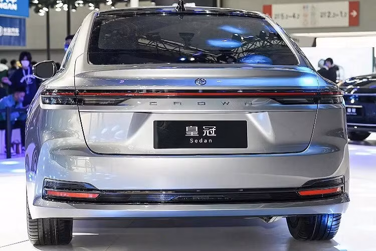 Ở phía sau, Toyota Crown Sedan 2024 gây ấn tượng với cụm đèn hậu LED mỏng và nằm vắt ngang đuôi xe. Phía trên đèn hậu là cánh gió đuôi nhỏ tích hợp vào cửa cốp. Trong khi đó, bên dưới đèn hậu là tem chữ nổi "Crown". Cản sau được tích hợp nẹp màu đen và đèn phản quang nằm ngang, kết hợp với đèn hậu khiến phần đuôi xe như rộng hơn.