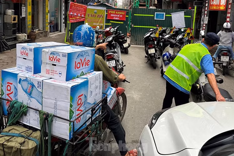 Với những xe máy chở theo hàng thì không thể nào leo lên vỉa hè, "chui" hàng rào để di chuyển qua công trường.