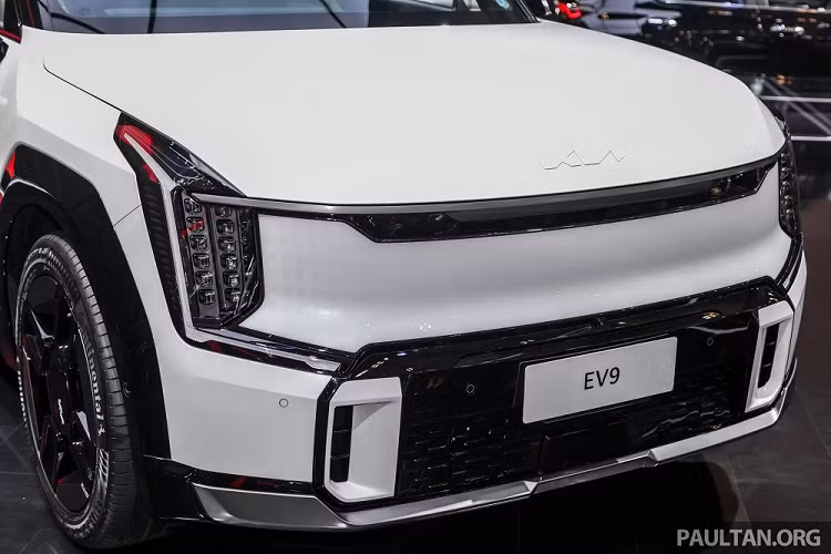 Không chỉ kích thước mà ngay cả thiết kế và trang bị của Kia EV9 GT-Line 2024 cũng không giống bản thường. Có thể thấy rõ điều này qua khu vực đầu xe với cản trước thể thao hơn, đi kèm ốp màu đen bóng và khe gió nổi bật hơn. Bên dưới cản trước còn có thêm ốp gầm màu bạc hầm hố, cùng với đó là lưới tản nhiệt kỹ thuật số (Digital Pattern Lighting Grille) được tích hợp hệ thống đèn ẩn.