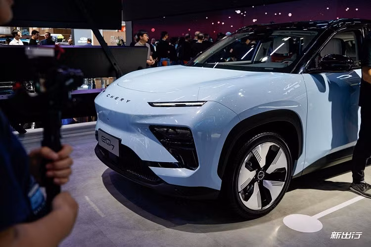 Ở bên sườn, Chery eQ7 sở hữu nóc dốc mượt mà về phía sau. Các cột và nóc đều được sơn màu đen, tạo hiệu ứng trôi nổi theo xu hướng. Đường chân kính của xe được thiết kế dốc dần lên ở cột C trong khi bên dưới là vành la-zăng 5 chấu khí động lực học. Tuy nhiên, không giống với nhiều mẫu ô tô điện đời mới khác, Chery eQ7 lại dùng tay nắm cửa thông thường thay vì loại nằm chìm vào thân xe.