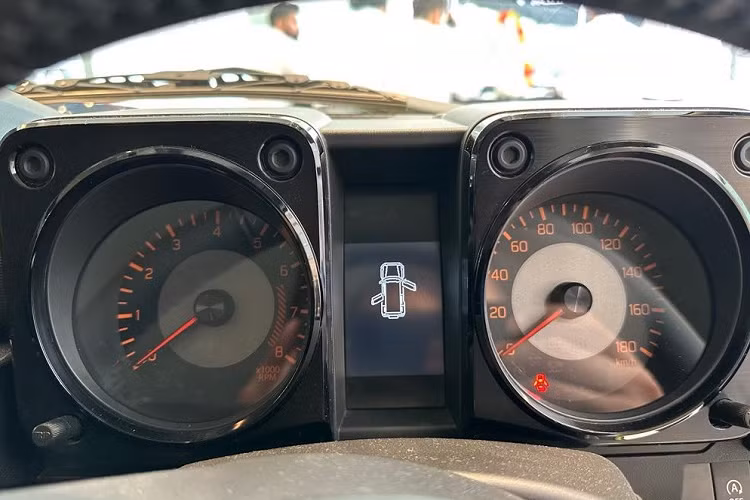 Những chi tiết nội thất dành riêng cho Suzuki Jimny 5 cửa bao gồm bảng đồng hồ hình chữ nhật với màn hình đa thông tin MID ở giữa. Ngoài ra, xe còn có tay nắm nằm trên mặt táp-lô, bên phía ghế phụ lái, nhiều hộc đựng đồ thông minh, dãy công tắc trên cụm điều khiển trung tâm và phanh tay chỉnh cơ.