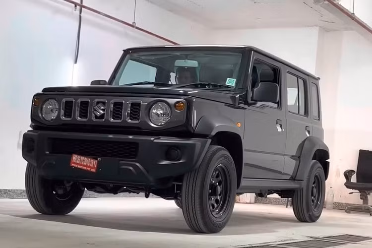 Phía sườn của xe, Suzuki Jimny 5 cửa bản Zeta chỉ được trang bị vành thép 15 inch, sơn màu đen. Trên chắn bùn trước còn có thêm đèn báo rẽ nhỏ trong khi gương chiếu hậu chỉ có tính năng chỉnh điện.