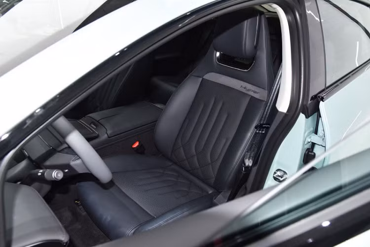 Aion Hyper GT cũng có các cột phía trước nghiêng và đường viền mái bóng bẩy. Do đó, Aion Hyper GT có hệ số cản cực thấp là 0,197 Cd. Nói về kích thước của xe, chiều dài x rộng x cao lần lượt là 4.886 x 1.885 x 1.449 mm với chiều dài cơ sở 2.920 mm. Nội thất của GAC Aion Hyper GT có màn hình cảm ứng nổi 14,6 inch và bảng điều khiển LCD 8,8 inch, về phần hộc trung tâm, nó có một cặp giá để cốc, hai đế sạc không dây và bệ tì tay.